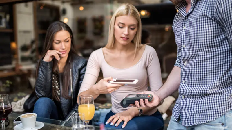 Un cliente que paga en un restaurante con NFC