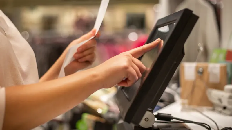a shopkeeper putting in the item in a POS system